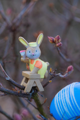easter bunny toy holding brush, background sunset 