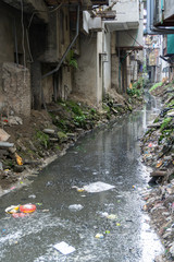 Dirty polluted waste water in big city with garbages. Environment pollution. Urban environment issues in developing countries