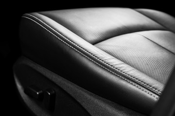 Modern Luxury car inside. Interior of prestige modern car. Comfortable leather seats. Perforated leather with stitching isolated on black background. Modern car interior. Car detailing. Car inside
