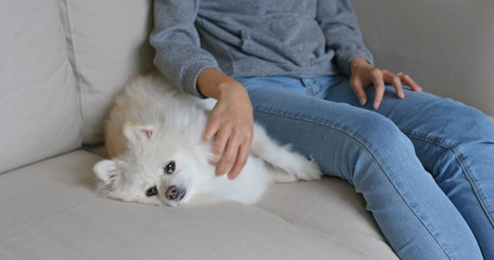 Woman cuddling on her pomeranian dog