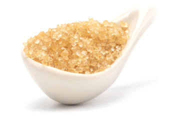 A brown sugar in the ceramic spoon close-up