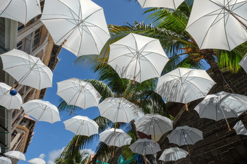 Fototapeta na wymiar White umbrellas urban street decoration
