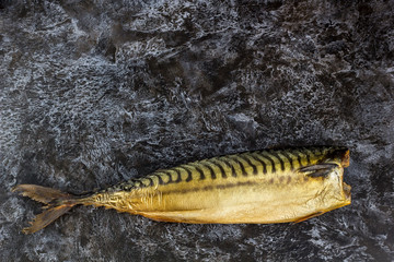 Smoked mackerel without head on black background. copyspace top view