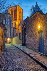 Small cobbled street in York at night with the famous Minster in the back