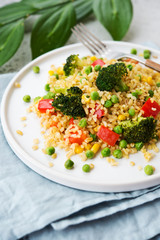 Lenten dish. Bulgur with vegetables in a plate. Pilaf from bulgur, broccoli, green peas, bell peppers and corn.