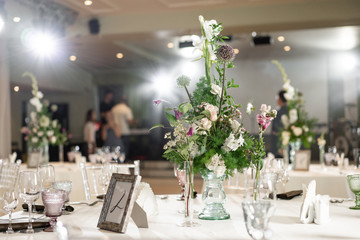 Floral decoration for wedding ceremony romance dining. Wedding banquet , festive decor. Bouquet from spring and summer flowers. Table layout. Restaurant interior. Concept of service and catering.