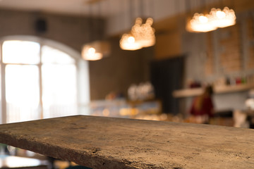 image of wooden table in front of abstract blurred background of resturant lights