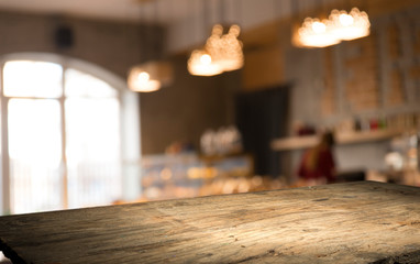image of wooden table in front of abstract blurred background of resturant lights