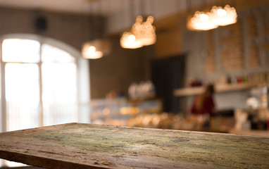 image of wooden table in front of abstract blurred background of resturant lights