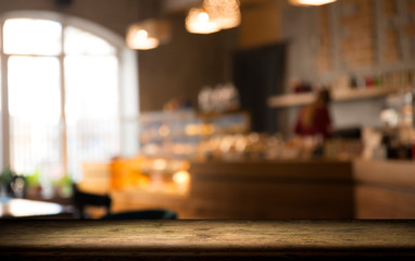 image of wooden table in front of abstract blurred background of resturant lights