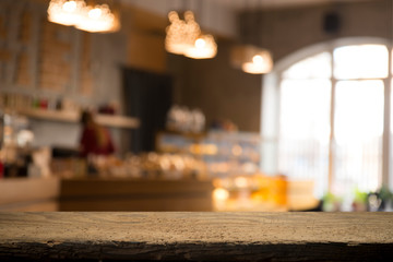 image of wooden table in front of abstract blurred background of resturant lights