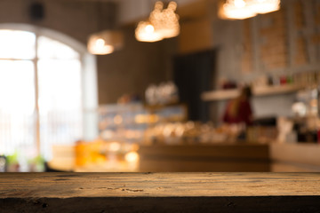 image of wooden table in front of abstract blurred background of resturant lights