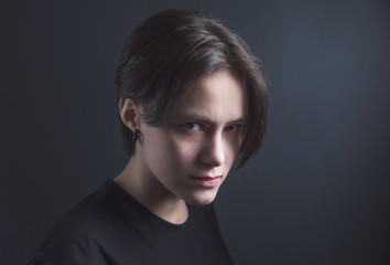 Portrait of an impulsive beautiful young girl with short hair in a black t-shirt and top