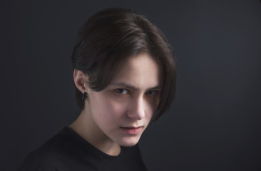 Fototapeta premium Portrait of an impulsive beautiful young girl with short hair in a black t-shirt and top