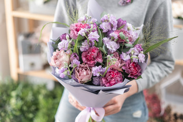 beautiful fresh cut bouquet of mixed flowers in woman hand. the work of the florist at a flower shop. Spring mood