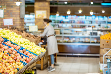 Woman buying apples in the supermarket, blurred image for the background
