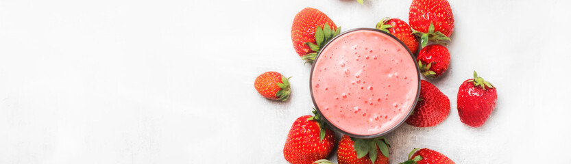 Strawberry smoothie in bottles on white table background, top view, copy space, top view, banner