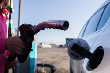 pumping petrol at gas station into vehicle.hand using a fuel nozzle at a gas station.Petrol Gasoline in Cold weather Safe drive concept.
