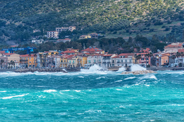 Fototapeta premium Stormy and Windy Mediterranean Sea with a Village in the Distance