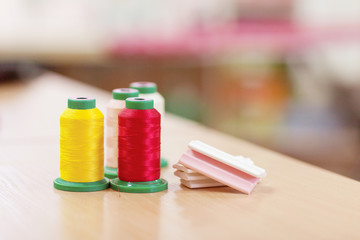 Sewing accessories on a wooden table close-up. Sewing thread and chalk for cutting