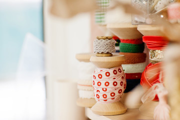 A set of sewing spools with a ribbon is on the desktop