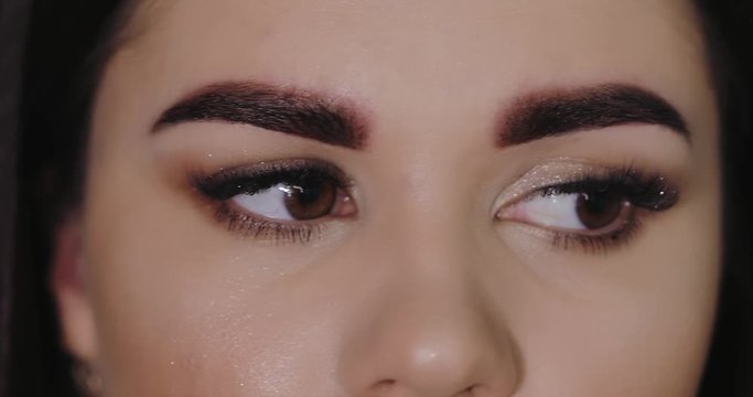 Young girl tweezing her eyebrows in a beauty salon. Eyebrow Correction. Beauty Concept. Permanent Makeup. Microblading brow.