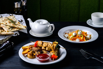 kebab and sauce on a black table in a cafe restaurant