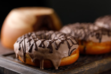 Cookery, baking and food concept - closeup. Donuts in the glaze on the decorative board.