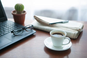 Newspaper with computer on table. Coffee break. 