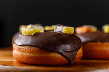 Concept of cooking, baking and food - close-up. Glazed donuts with marmalade decoration on a decorative board.