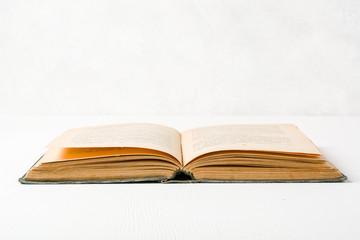 Old unfolded book lying on the table. Yellow paper pages. Plenty of space for text or photo.