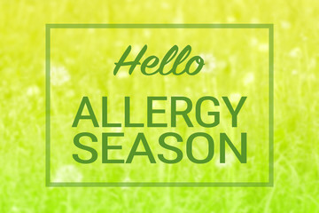 Natural green grass and flowers background and hello allergy season text sign. Spring summer seasonal allergies concept.