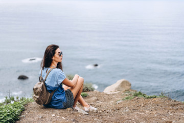 Pretty brunette girl in sunglasses relaxing outdoor in the mountains.