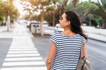 Pretty long hair tourist girl walking on the street.