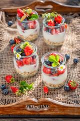 Delicious granola with berries and yoghurt in jar