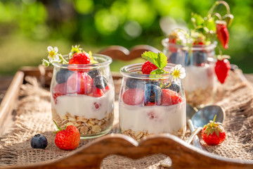 Tasty granola with berries and yoghurt in jar