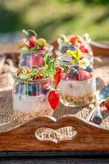 Tasty oat flakes with berries and yoghurt in jar