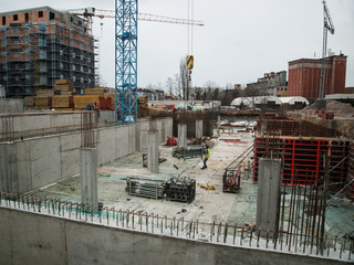 Naklejka premium View of apartment building with offices under construction with crane. Development of city.