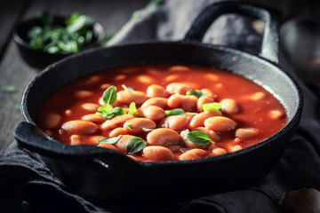 Spicy baked beans with tomato sauce and fresh herbs