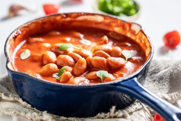 Hot baked beans with garlic and fresh tomatoes
