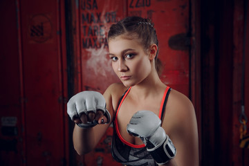 Boxer MMA female fighter posing in confident defensive stance with gloves up