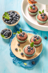 Tasty cupcake with blueberries and chocolate cream