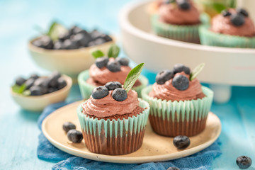 Fresh cupcake with blueberries and chocolate cream