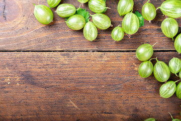 ripe green gooseberries on a wooden background.