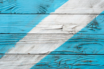 The texture of old wooden shield with shabby surface painted in cyan and white colors