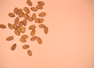 Obraz premium Isolated almond nuts on the live coral solid background