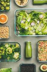 Healthy vegan dishes in glass containers. Flat-lay of vegetable salads, legumes, beans, olives, sprouts, hummus and fresh juices in bottles over concrete table, top view. Spring menu, weight loss food