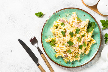 Pasta carbonara with zucchini in craft plate on white. 