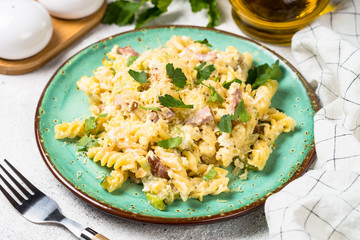 Pasta carbonara with zucchini in craft plate on white. 