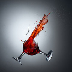 Collision of wine glasses with shattered glass and wine splash